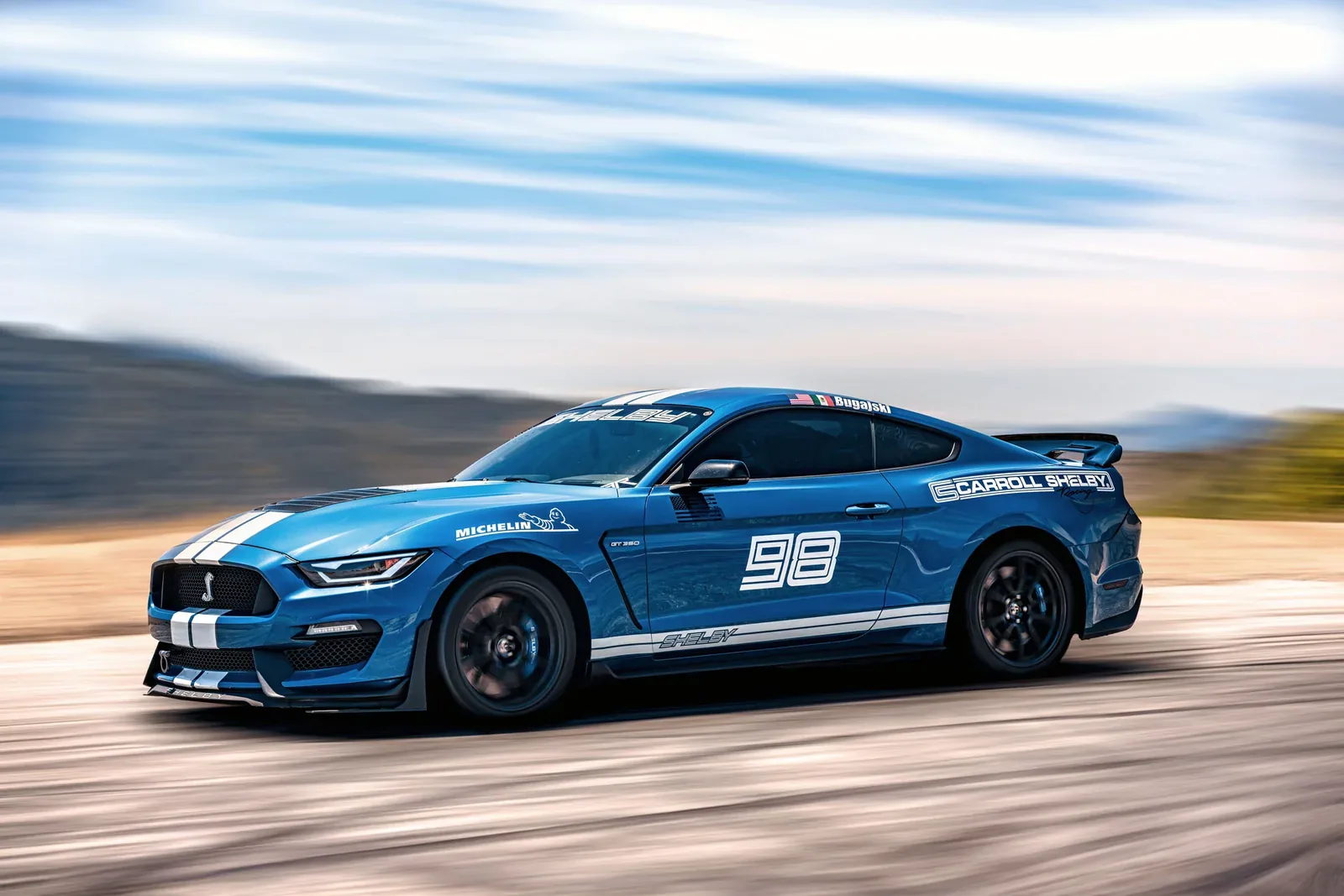Mustang azul en la carretera costera