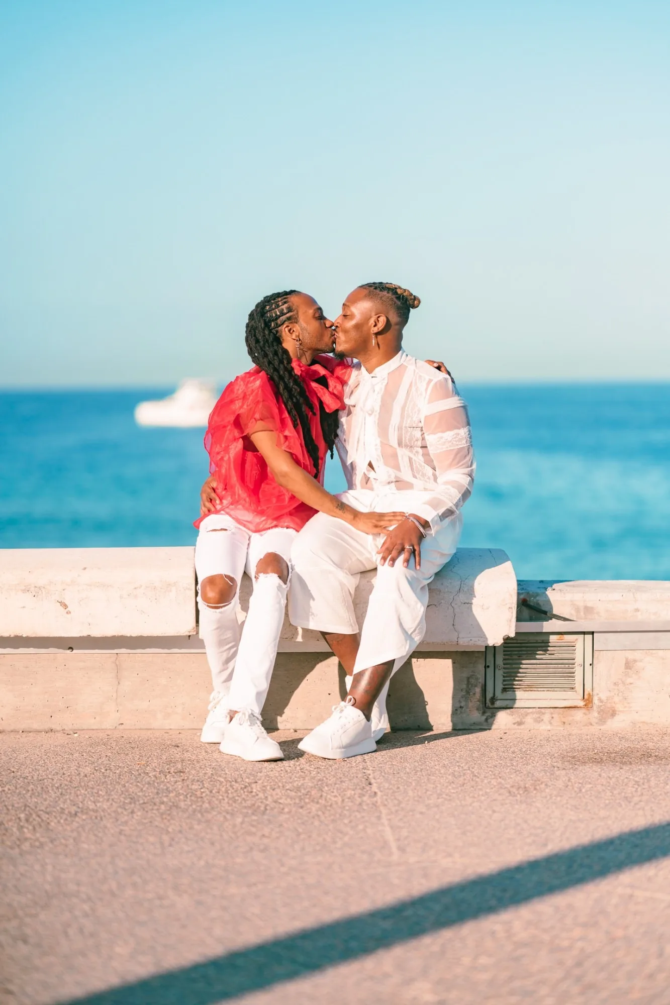 Pareja besándose en un malecón frente al mar