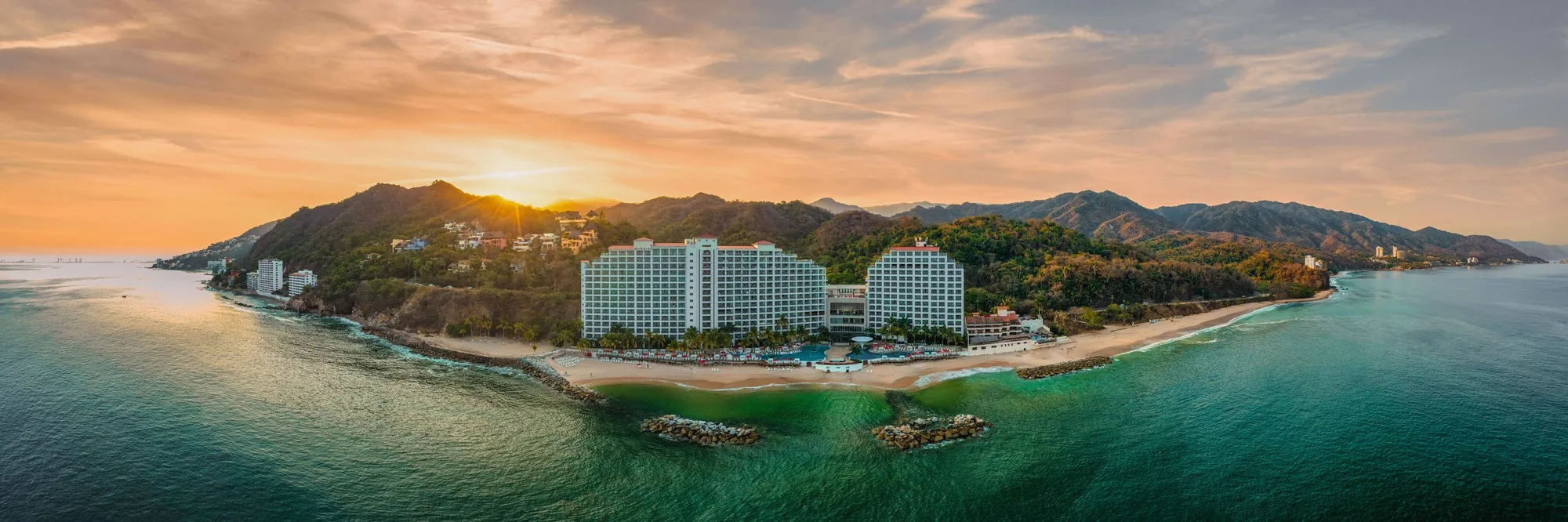 Toma aérea de un resort frente a la playa al atardecer, Puerto Vallarta